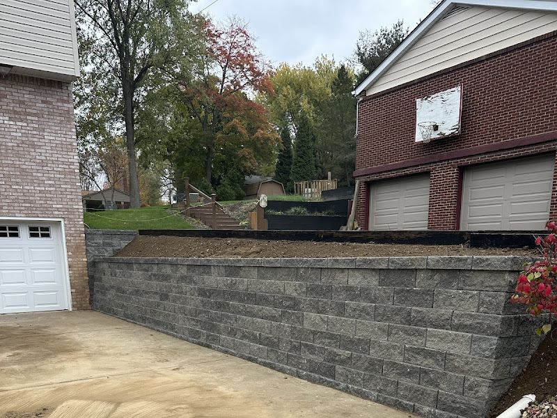 Completed segmental block retaining wall along a driveway, a real Retaining Walls LLC job