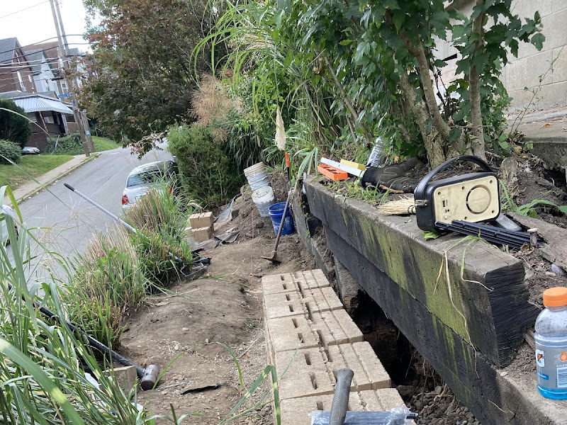 Retaining wall job mid-construction with materials and tools on site, a real Retaining Walls LLC project